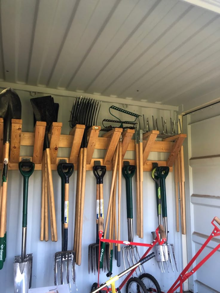 there are many gardening tools hanging on the wall