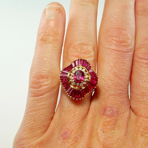 a woman's hand with a ring on it and a pink stone in the middle