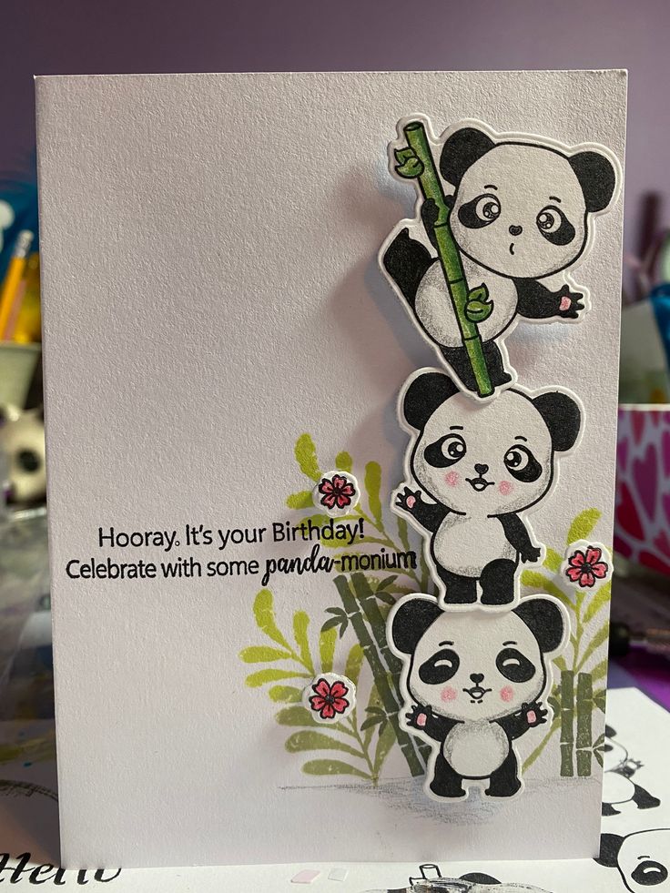 a card with pandas and flowers on it