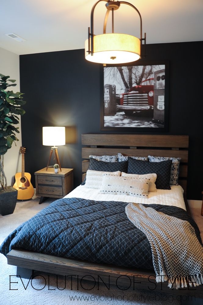 a bed room with a neatly made bed and a painting on the wall above it