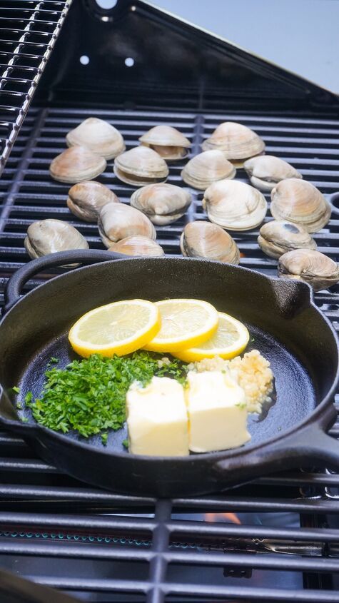 some food is cooking on a grill with lemons and other foods in the background