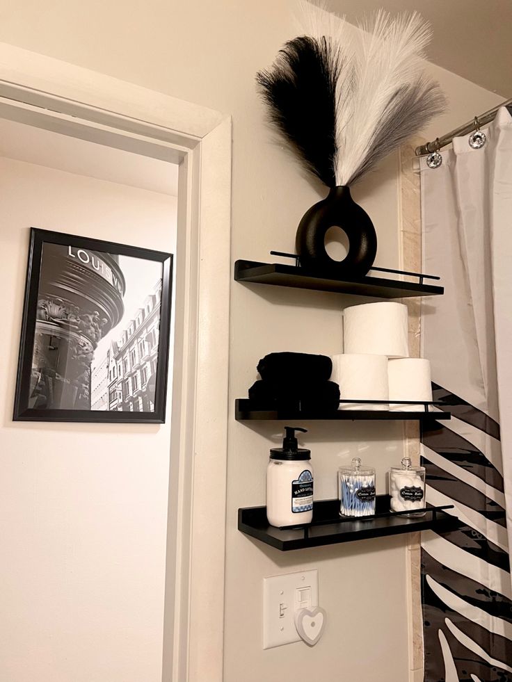 the bathroom is clean and ready for us to use it's shelves are decorated with black and white decor