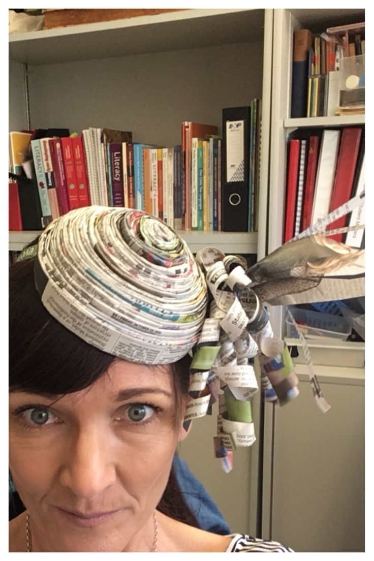 a woman wearing a hat made out of newspapers