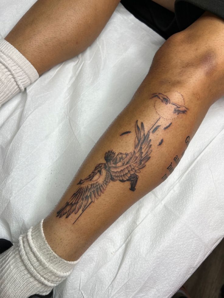 a person with a bird tattoo on their arm and leg sitting in a hospital bed