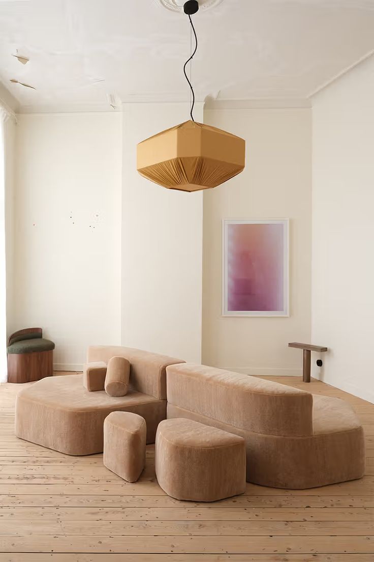 a living room filled with furniture and a lamp hanging over the top of it's head