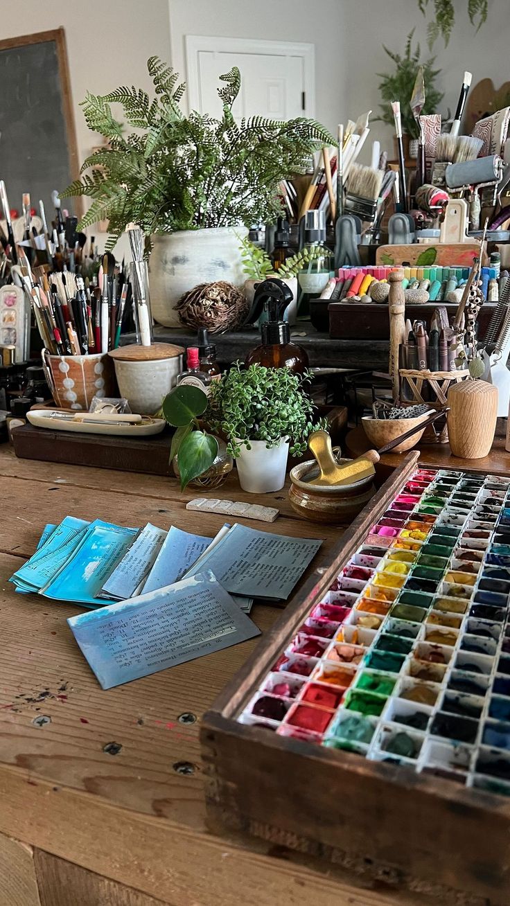 a wooden table topped with lots of art supplies