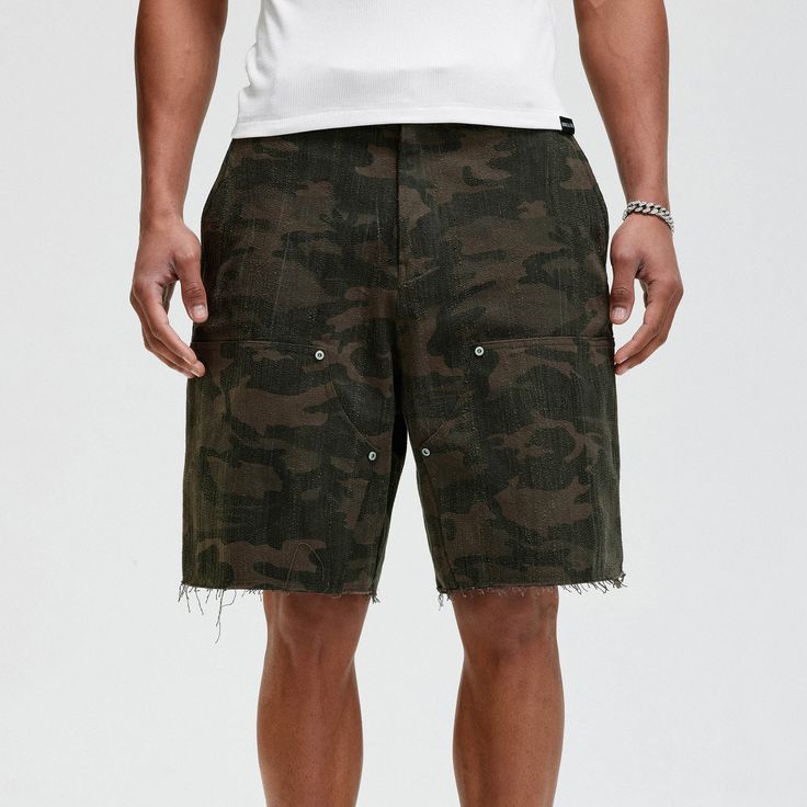 The Frayed Double-Knee Camo Cargo Shorts masterfully blend military elements with street style. These slightly oversized shorts feature an all-over camouflage print and a durable double-knee design for added toughness. The frayed hem adds an edgy touch, while the back pocket is adorned with a metal logo badge for a distinctive look. Crafted from premium 100% cotton fabric (370g/m²), these shorts ensure both comfort and durability, making them perfect for any urban adventure. All-over camouflage Military Camouflage Relaxed Fit Bottoms, Military Camouflage Bottoms With Relaxed Fit, Relaxed Fit Camouflage Military Bottoms, Camouflage Cargo Shorts With Built-in Shorts For Summer, Urban Camouflage Bottoms Relaxed Fit, Spring Camouflage Bottoms For Streetwear, Military Camouflage Bottoms For Streetwear, Military Style Cargo Shorts, Camouflage Military Cargo Shorts For Summer