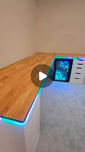 a computer desk with an illuminated drawer underneath it and a video playing on the screen