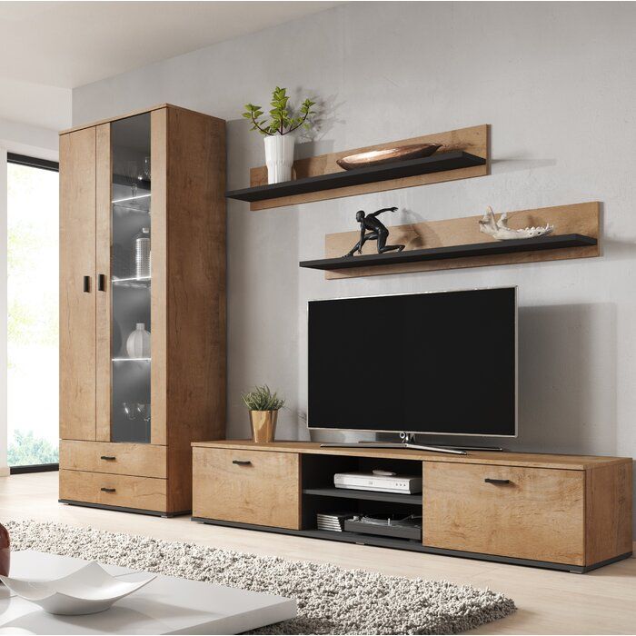 a living room with a large tv on the wall and wooden furniture in front of it