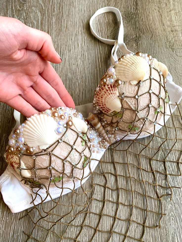 two seashells are being held by someone's hand