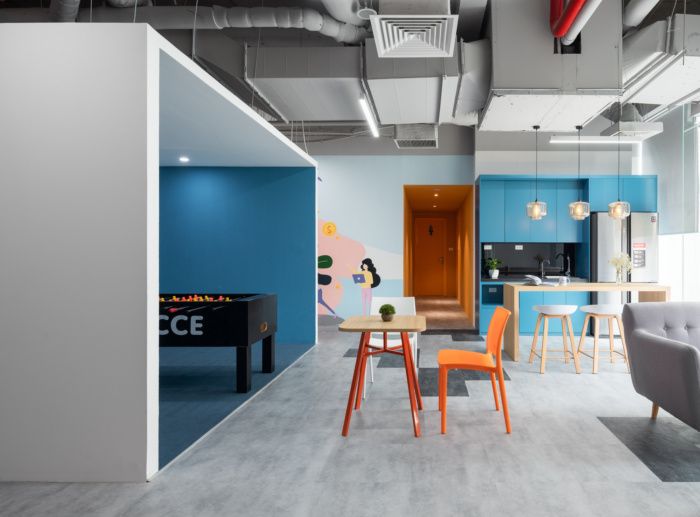 an office with blue walls and white ceilinging, two chairs and a table in the middle