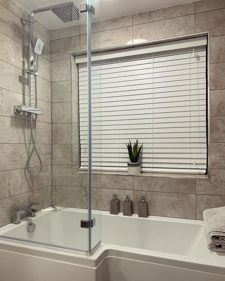 a bath tub sitting next to a window in a bathroom