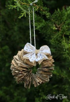 an ornament hanging from a tree branch in the shape of a wreath with a bow