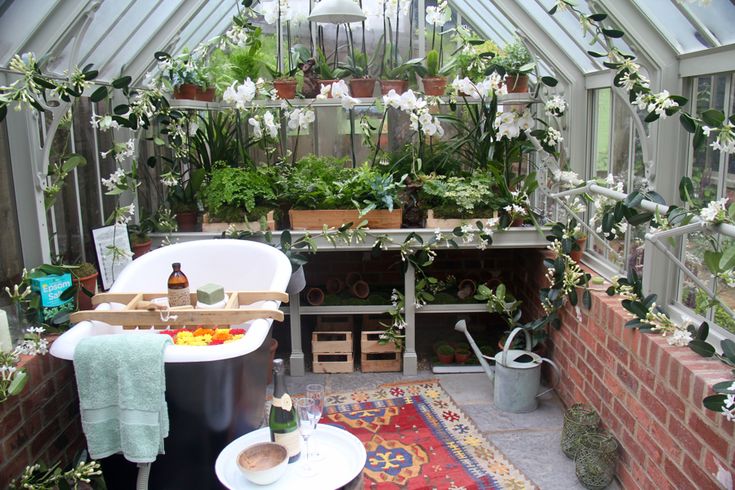 an indoor greenhouse with lots of plants and flowers in the room, including potted plants