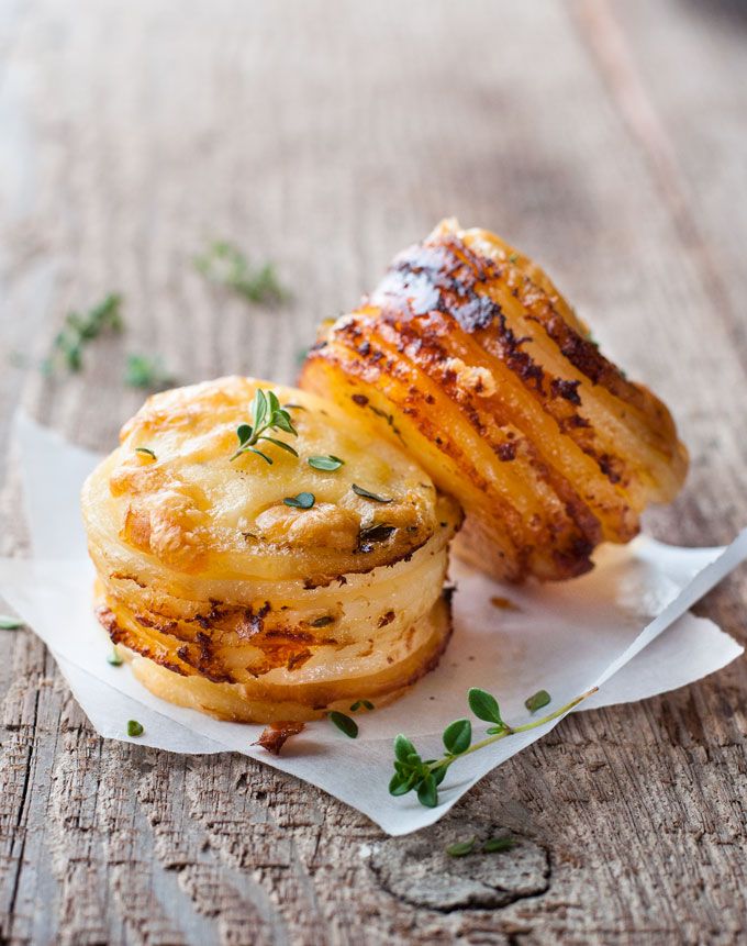 two pastries sitting on top of white paper with green sprigs around them