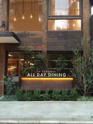 an all day dining sign in front of a building with plants growing out of it