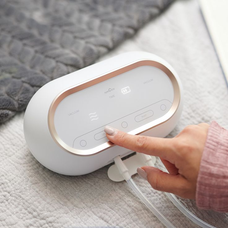 a woman is pressing the button on an alarm clock that's connected to her bed