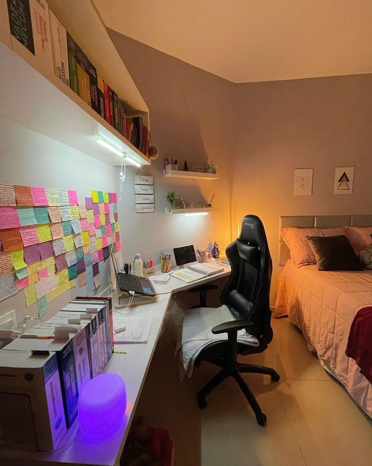 a room with a bed, desk and chair in it that has sticky notes on the wall