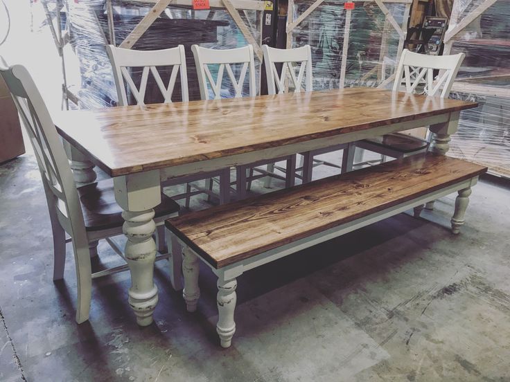 a wooden table with white chairs and benches