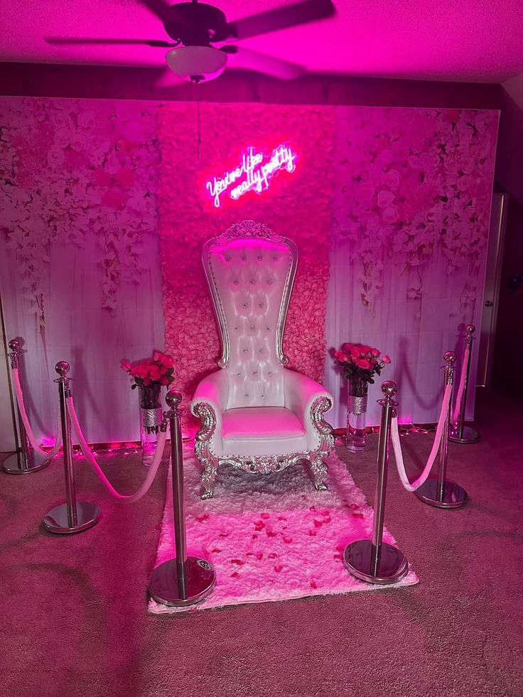 a fancy chair with pink lighting in a room that is decorated for valentine's day