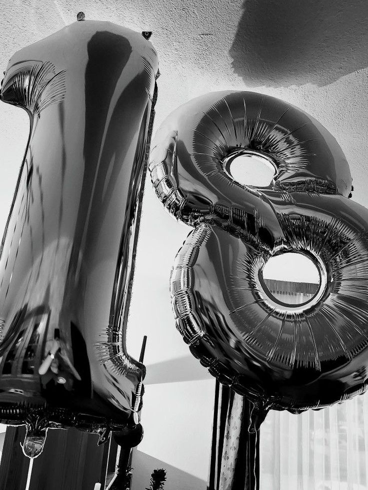 black and white photograph of giant balloons in the shape of the number eight on display