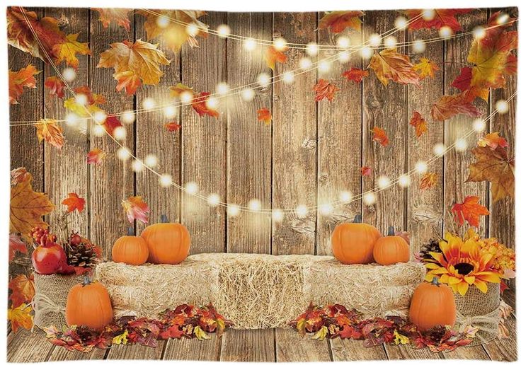 an autumn scene with pumpkins and lights on a wooden table covered in fall leaves