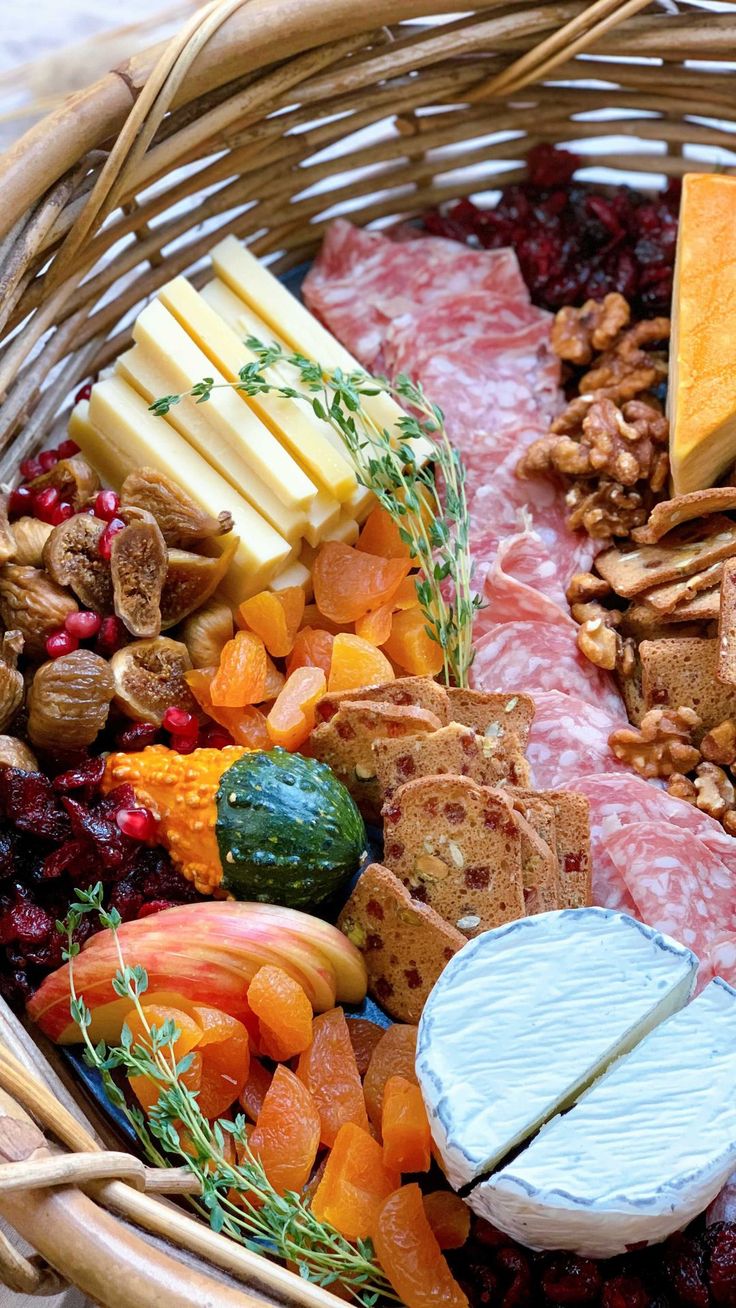 an assortment of cheeses and meats in a basket with nuts, cranberries