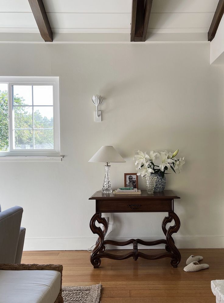 a living room with white walls and wood floors