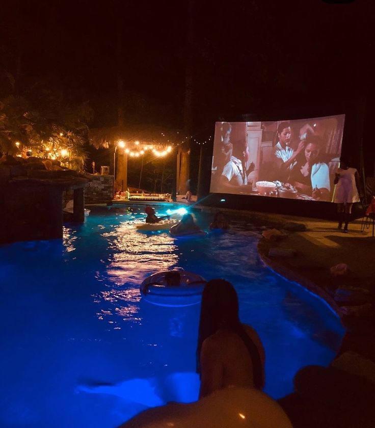 people are watching movies in the pool at night