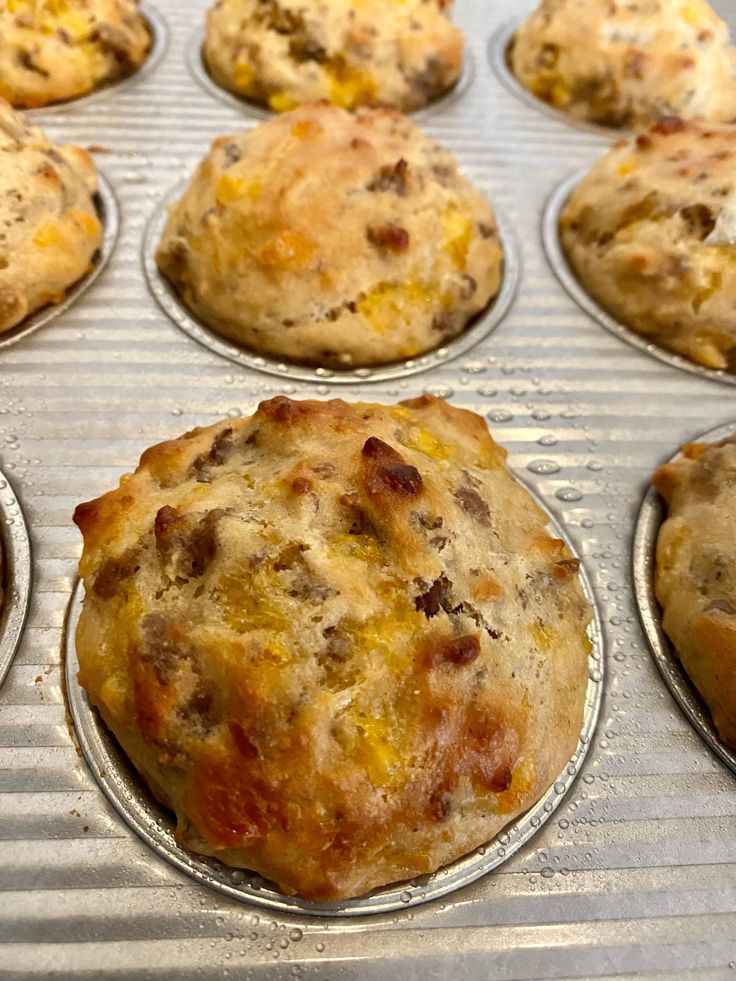 some muffins are sitting in the pan on top of each other and ready to be baked