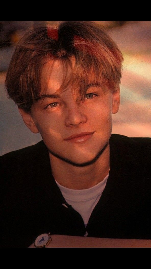 a young man with blonde hair wearing a black shirt