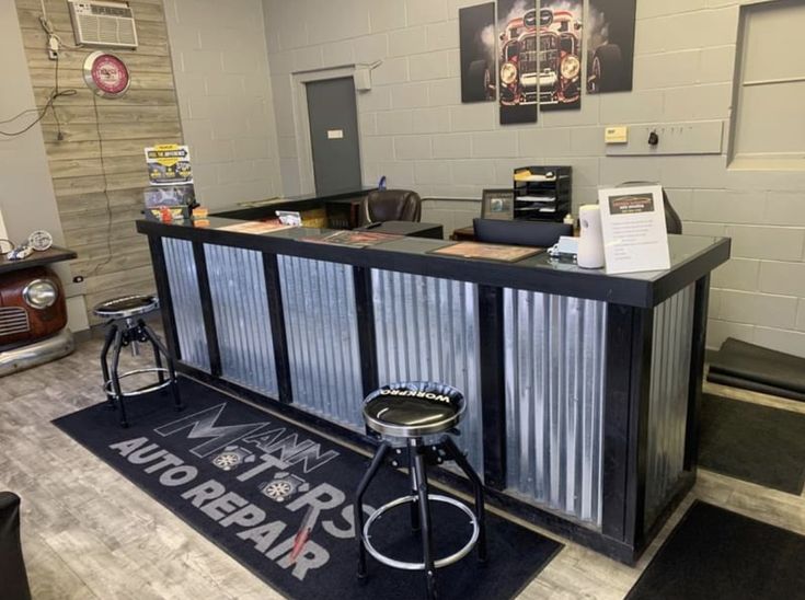 the front desk of an auto repair shop with stools and other items on display