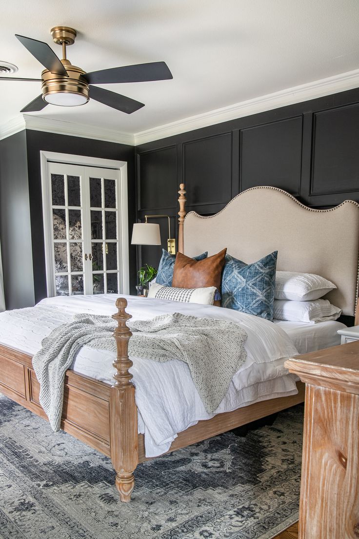 a bedroom with a bed, dresser and ceiling fan in the middle of the room