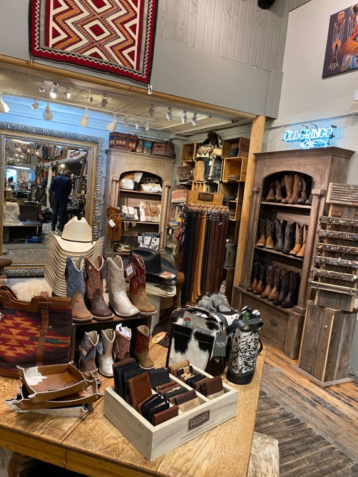 a room filled with lots of different types of shoes and hats on top of a wooden table