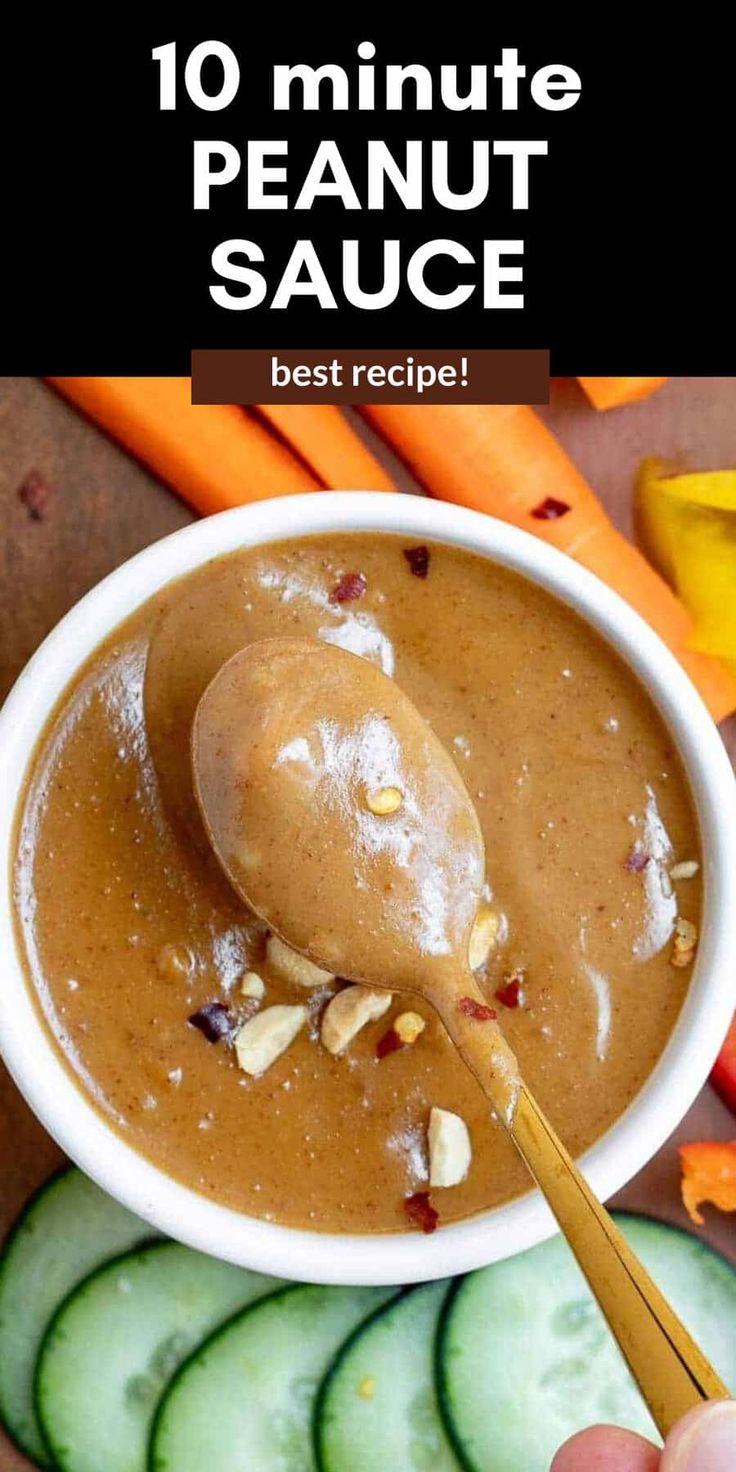 a person spooning peanut sauce into a bowl with cucumbers and carrots