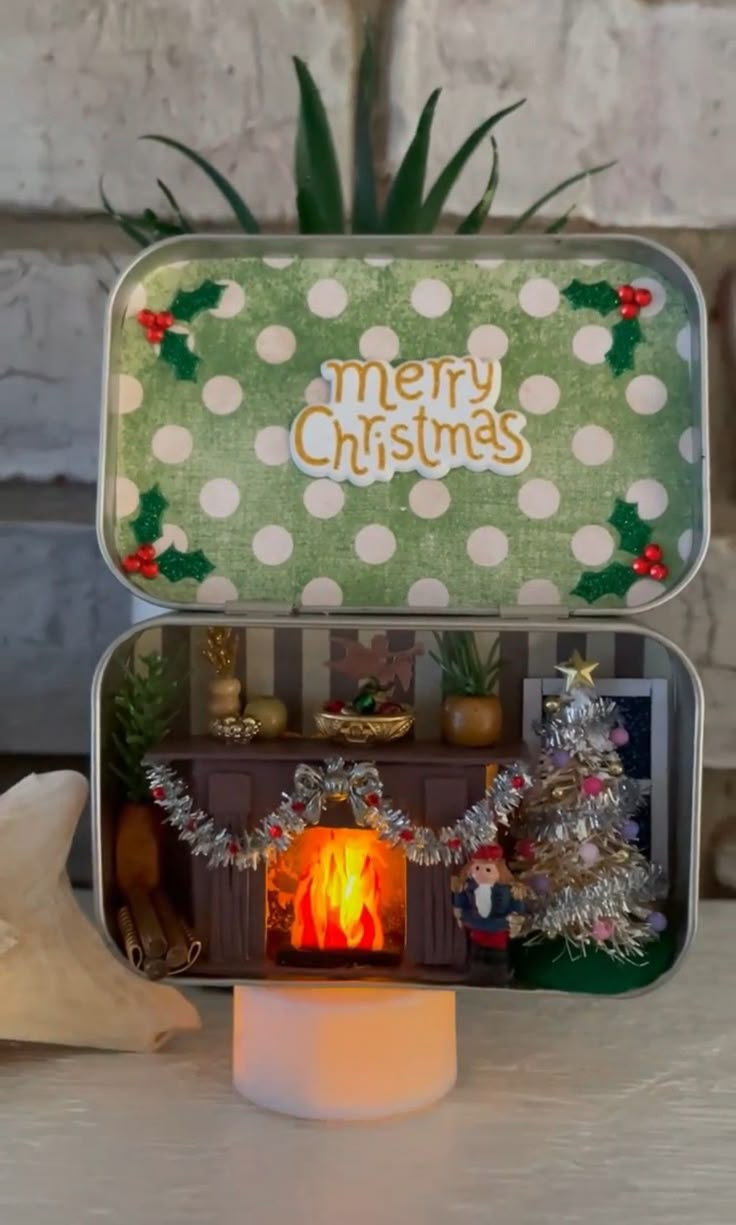 an open tin can with christmas decorations on it and a lit candle in the middle