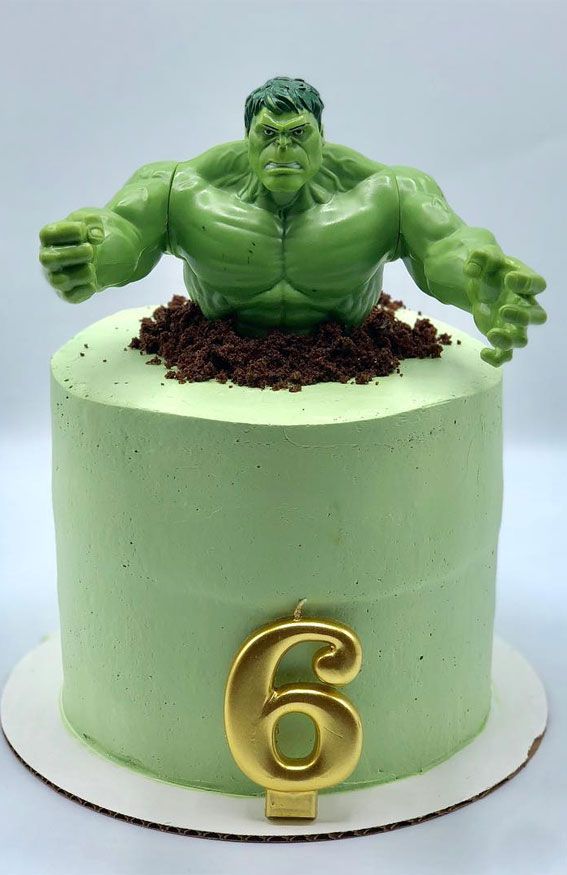 there is a green cake with a gold number 6 on it and a hulk figure in the middle