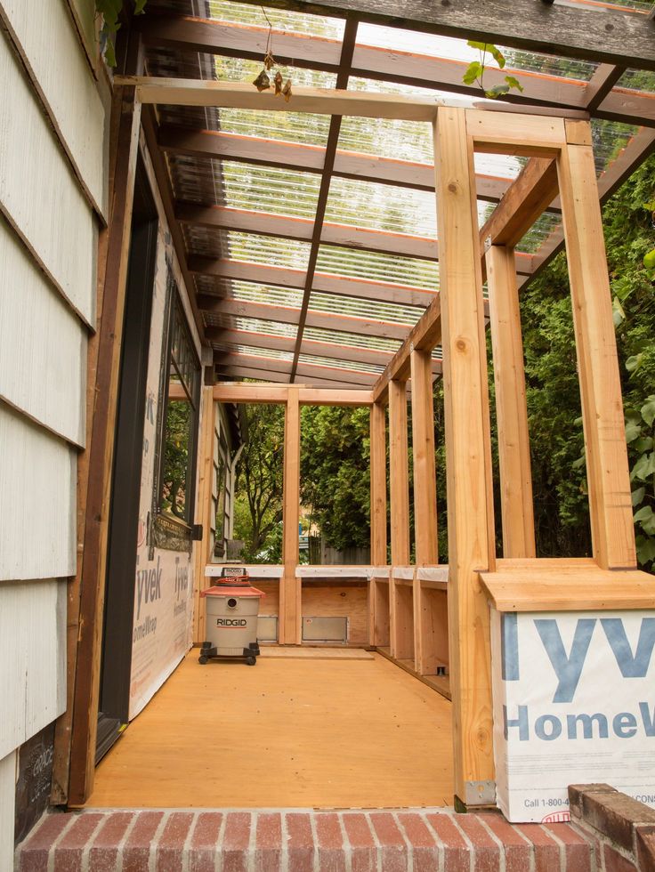 an open porch is being built on the side of a house with wood framing and brick steps