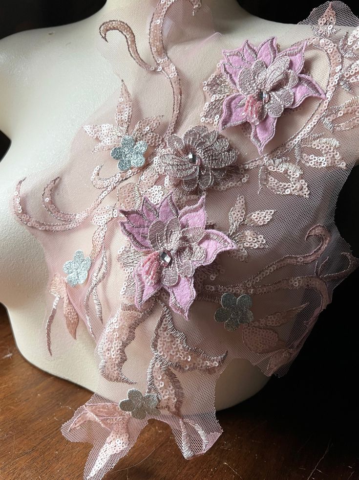 a white mannequin with pink and purple flowers on it's back side