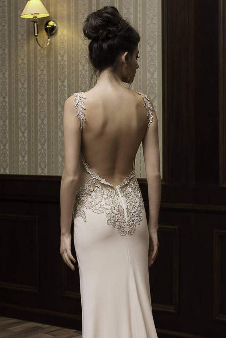 the back of a woman's wedding dress, with an open back and beaded detailing