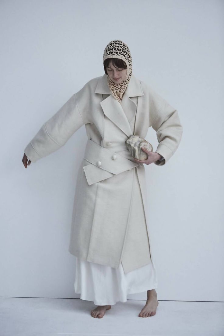 This sweeping statement coat exudes oversized elegance with its wide lapels leading to a romantic deep V neckline. Falling just above the ankles, the Snegurochka Cream Wool Hemp Shell Buttons Coat is both cozy and sophisticated. Made from a blend of durable hemp and wool fibers, its sturdy structure is punctuated with uniquely handcrafted ceramic shell buttons. Lined.Composition 40% Hemp 60% Wool and it´s undyed.Lining 100% viscoseTrimming 100% ceramic glazed handmade shell buttonsSizesOversize. Elegant Oversized Outerwear With Lapel Collar, Spring Double-breasted Wool Coat, Winter White Long Outerwear For Spring, Spring Wool Long Pea Coat, Elegant Oversized Long Wool Coat, Elegant Neutral Outerwear With Double-breasted Button Fastening, Elegant Neutral Outerwear With Double-breasted Button, Elegant Beige Double-breasted Wool Coat, Elegant Neutral Double-breasted Outerwear