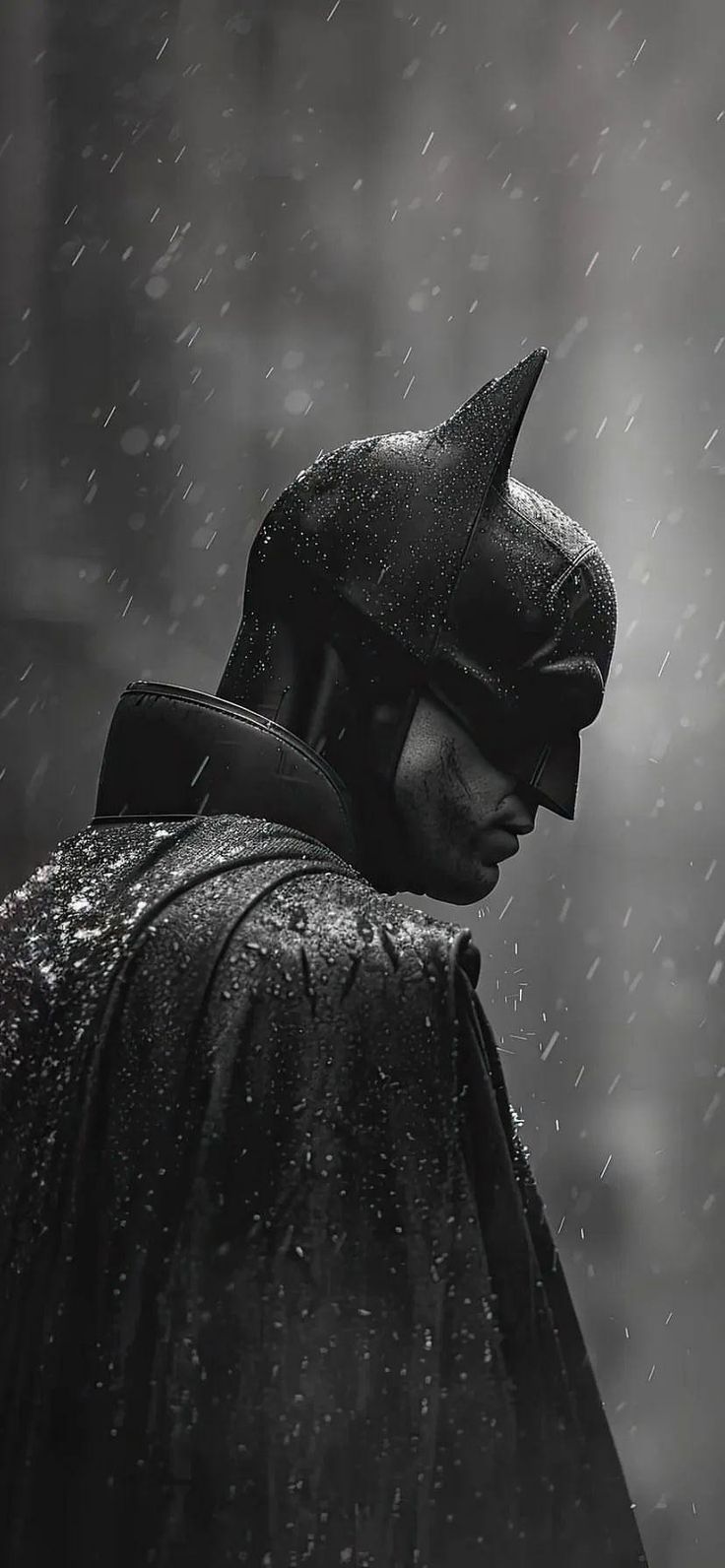 a man dressed as batman standing in the rain with his head turned to the side