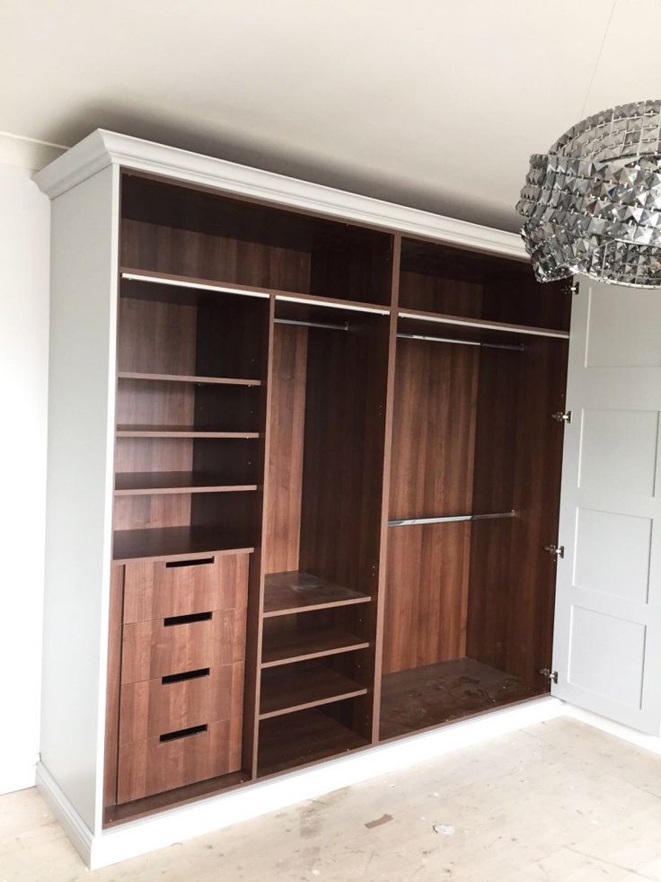 an empty room with wooden closets and chandelier