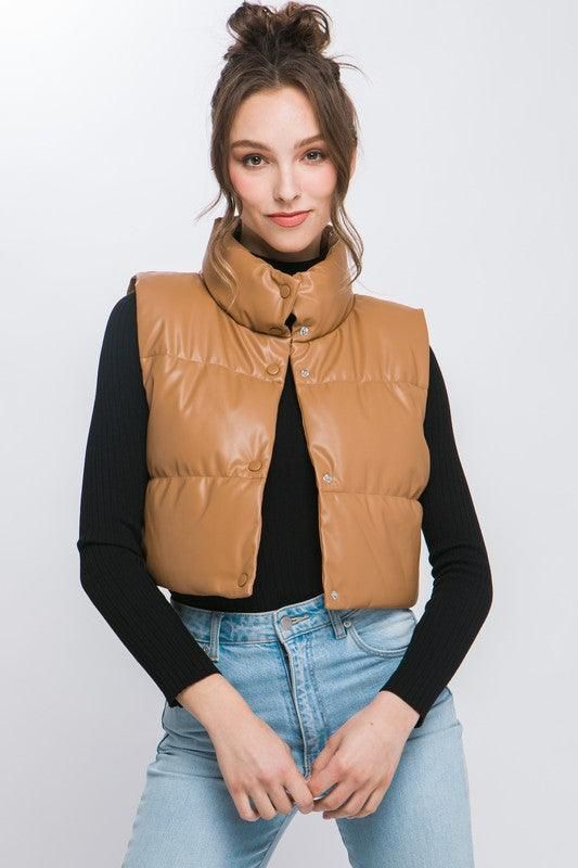 Add a touch of edgy style to your casual outfits with our PU Faux Leather Puffer Vest. This trendy puffer vest is perfect for layering over your favorite tops. This is a versatile and must-have addition to your casual wardrobe, perfect for staying warm and fashionable during cooler days. Style: Casual Print / Pattern: PU Faux Silhouette: Puffer Vest Fit: Regular Embellishment: Button Neck Line: Collar Sleeve: Sleeveless Length: Cropped Closure: Button Lining: Yes Fabric Contents: 100% Polyuretha Faux Leather Puffer Vest, Leather Puffer Vest, Leather Button Up, Leather Puffer, Puff Vest, Button Shirts, Cropped Vest, Edgy Style, Leather Vest