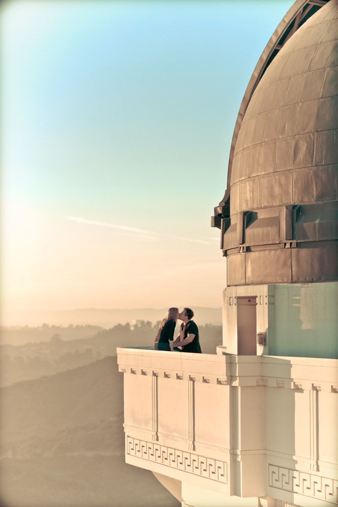 two people standing on top of a tall building