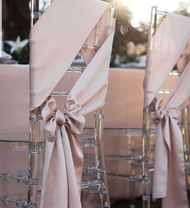 two chairs with bows tied to them sitting next to each other