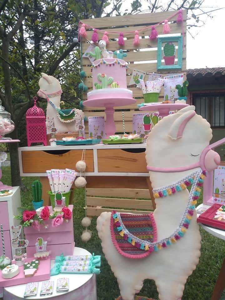 a horse is standing in the grass next to some cakes and desserts on display