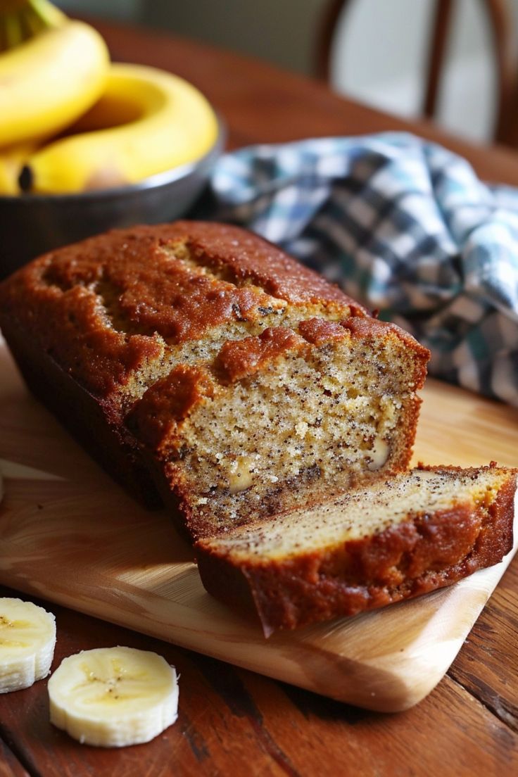 Banana bread loaf on a cutting board with a slice cut, next to bananas and a checkered cloth. Gluten Free Banana Bread Almond Flour, Banana Bread Without Flour, Rice Flour Banana Bread, Banana Bread Recipe Almond Flour, Banana Bread With Oat Flour, Banana Bread With Almond Flour, Easy Gluten Free Banana Bread, Gf Banana Bread, Banana Bread Almond Flour