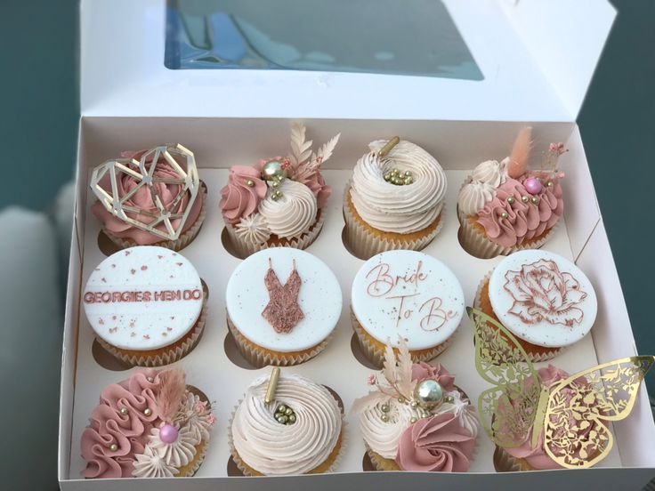 a box filled with lots of cupcakes on top of a white countertop