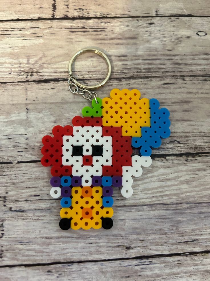 a keychain made out of perler beads with an image of a skull on it